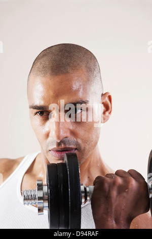 Mann Arbeit Kleidung tragen und heben von Gewichten im Studio mit weißem Hintergrund Stockfoto
