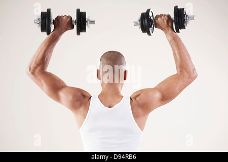 Mann Arbeit Kleidung tragen und heben von Gewichten im Studio mit weißem Hintergrund Stockfoto