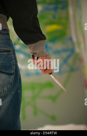 Nahaufnahme von junger Mann mit Messer mit Grafitti in Hintergrund, Mannheim, Baden-Württemberg, Deutschland Stockfoto