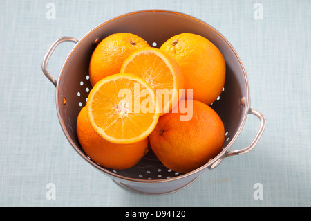 Draufsicht der Orangen in Sieb auf blauem Hintergrund, Studioaufnahme Stockfoto