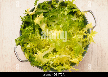 Draufsicht von Salat in Sieb für Salat auf Beige Hintergrund, Studioaufnahme Stockfoto