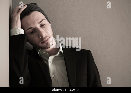 Porträt des jungen Mannes Wollmütze und Anzugjacke, auf der Suche nach unten, übertragenden in Gedanken, Studioaufnahme Stockfoto