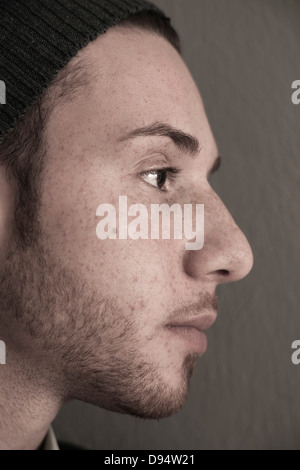 Nahaufnahme, Side View of Young Man trägt Wollmütze, Studioaufnahme Stockfoto