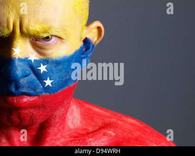 Mann und sein Gesicht gemalt mit der Flagge Venezuelas. Der Mann ist ernst und fotografischen Komposition lässt nur die Hälfte der fac Stockfoto