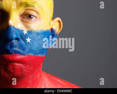 Mann-Gesicht mit venezolanischen Flagge gemalt. Der Mann ist traurig und fotografischen Komposition lässt nur die Hälfte des Gesichts. Stockfoto