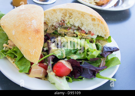 Thunfisch-Salat-Sandwich mit Ciabatta-Brot und grüner gemischter Salat mit Tomaten Stockfoto