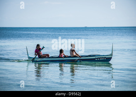 Kinder in einem traditionellen Boot Beschleunigung von Bounty Beach, Malapascua Island, Daanbantayan, Cebu, Central Visayas, Philippinen Stockfoto