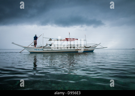 Fischer umstoßen traditionellen Auslegerboot flachen Meeren der Bounty Beach Malapascua Insel, in der Nähe von Cebu City, Philippinen Stockfoto