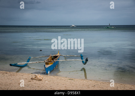 Bangka oder traditionelle Filipino Fischerboot mit Auslegern vertäut am San Juan, Siquijor, Central Visayas, Cebu, Philippinen Stockfoto