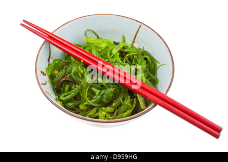 Seetang Salat in Keramikschale mit roten Holzstöcken isoliert auf weißem Hintergrund Stockfoto