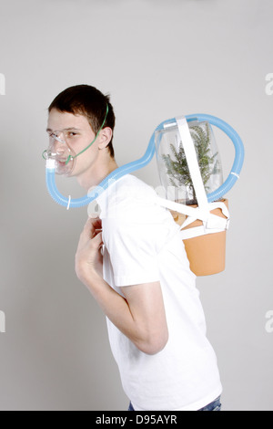 Ein kleiner Junge Durchfürung einer Sauerstoff-Luft-Pack mit einem Baum, sauberen Luft zu produzieren Stockfoto