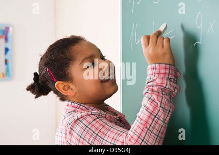 Mädchen, die Beantwortung der Frage an der Tafel im Klassenzimmer, Baden-Württemberg, Deutschland Stockfoto