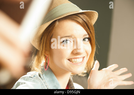 Kopf und Schultern Porträt von Teenager-Mädchen mit Hut im Atelier. Stockfoto