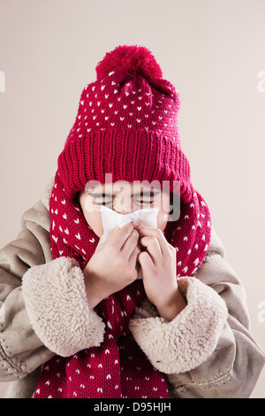 Portraif der Mädchen mit Hut und Schal weht Nase im Studio Stockfoto