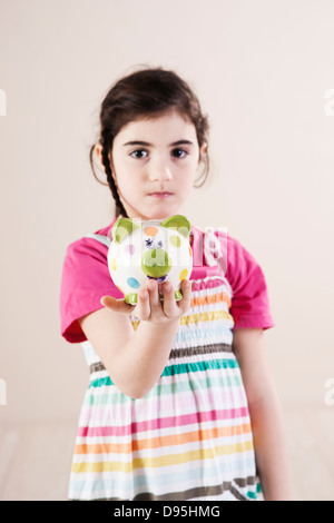 Porträt eines Mädchens mit Sparschwein in Studio Stockfoto