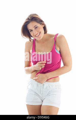 Porträt der jungen Frau trägt Tank Top und Shorts im Studio Stockfoto