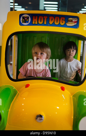 3 Jahre alter Junge treibt einen Spiel-Hot-Dog-LKW mit ein 3 Jahre altes Mädchen als Beifahrer im Einkaufszentrum, Sydney, Australien Stockfoto