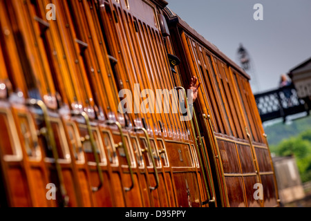 Der Bluebell Railway in East Sussex, UK. Eine Wache Wellen aus einem abfahrenden Zuges in Sheffield Park. Stockfoto