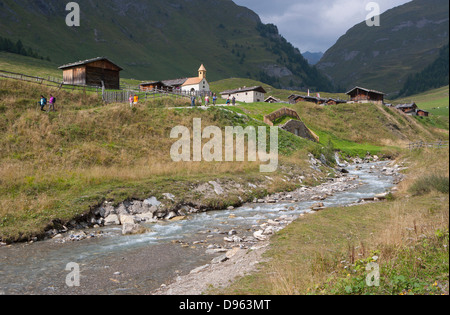 Italien, Ansicht der Pfunderer Berge und Gebirge Dorf mit Wanderer zu Fuß in der Nähe von stream Stockfoto