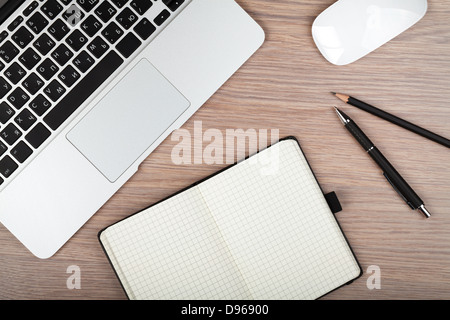 Notizblock und Laptop auf Holztisch. Ansicht von oben Stockfoto