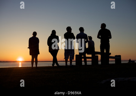 Eine Gruppe von Freunden den Sonnenuntergang über der Bucht von Dublin in Irland. Stockfoto