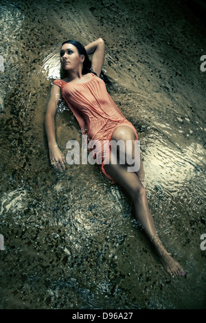 Frau im nassen Kleid im Bachbett Stockfoto
