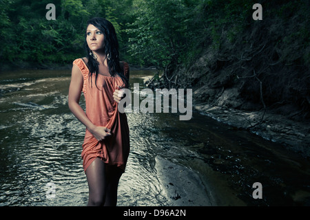 Frau im nassen Kleid im Bach Stockfoto