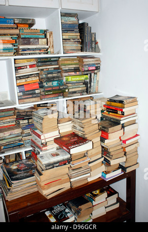 Ein Stapel Bücher gestapelt und auf einem Kuchengitter Buch in einer Bibliothek Regal angeordnet Stockfoto