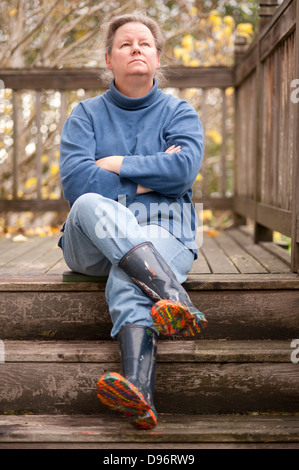 Frau sitzt auf Schritte mit dem alleinigen Tropfen Lack Stiefel Stockfoto