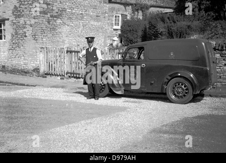 Historische der 1950er Jahre. Ländlichen England und britische Royal Mail Postbote steht stolz mit seinem Lieferwagen. Stockfoto