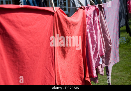 Rot rosa und lila Kleidung auf der Wäscheleine trocknen Stockfoto