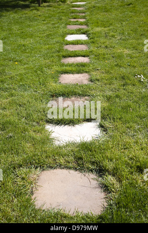 Stepping stone ebnet Platten Form einen Weg über den Rasen in einem Garten, UK Stockfoto