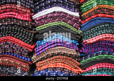 Haufen von handgefertigten Alpaka Wolle Schals in einer Vielzahl von Farben bei der Outdoor-Kunsthandwerksmarkt in Otavalo, Ecuador Stockfoto