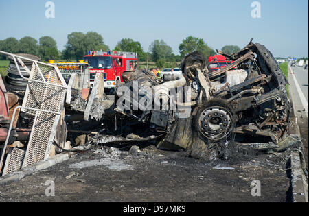 Ein Traktor Anhänger ruht auf den Median und drei Fahrspuren der Autobahn A8 in der Nähe von Sulzemoos, Deutschland, 13. Juni 2013 ausgebrannt. Zwei zusätzliche Autos fuhren in den Anhänger. Mindestens eine Person starb bei dem Unfall, und zwei wurden schwer verletzt. Foto: MARC Müller Stockfoto