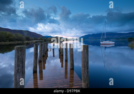 Holzsteg und Yacht auf Derwent Water in der Nähe von Lodore, Lake District, Cumbria, England. Herbst (Oktober) 2012. Stockfoto