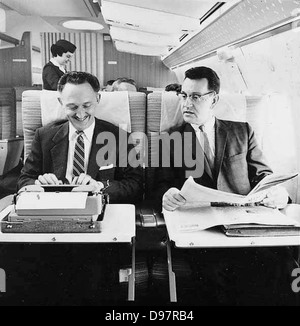 Zwei Männer auf Northwest Airlines Flugzeuge, eins mit Schreibmaschine, mit weiblichen Flugbegleiter im Hintergrund Stockfoto