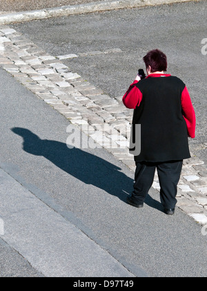 Draufsicht der übergewichtige Frau zu Fuß mit tragbaren Telefon - Frankreich. Stockfoto