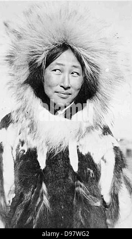 Dieses Foto zeigt eine Eskimo-Frau, die einen Pelzparka mit Pelzbesatz trägt, wie sie bei Inupiaq in Alaska üblich ist. Sie spiegelt die traditionelle Kleidung, die in kalten Klimazonen getragen wird, und die kulturellen Praktiken der Region wider. Stockfoto