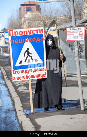 Tod mit Sense und Zeichen "Weg für Fußgänger auf der Straße neben dem Fußgängerüberweg geben". Sankt-Petersburg, Russland Stockfoto
