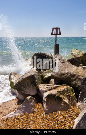 Wellen plätschern / stürzt ab auf Wellenbrecher steinerne Buhne am Strand von Hengistbury Head Stockfoto