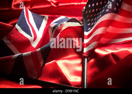 Closeup auf Miniatur Vereinigte Staaten und Vereinigtes Königreich Fahnen auf rotem satin in Studioumgebung Stockfoto