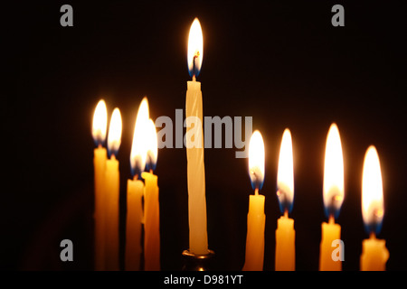 Closeup auf Kerzen beleuchteten Menorah vor schwarzem Hintergrund Stockfoto