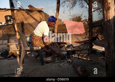 Esther Khoza 57 Jahre alte Mutter bereitet drei Feuer zu kochen in der Küche lebt in Schlamm Hütte ohne Strom Stockfoto