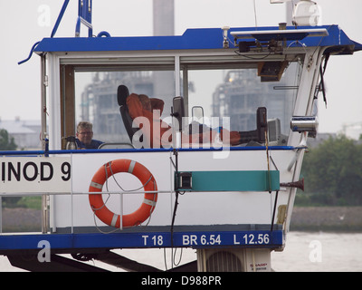 Mann, die Lenkung sein Frachtschiff über den Hafen von Rotterdam in einer sehr entspannten Position. die Niederlande Stockfoto