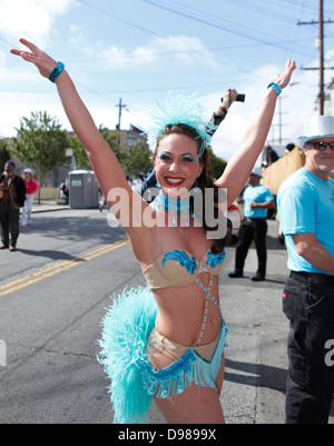 schöne Frau, die auffällig einer Pose im Karnevalstreiben im Mission District in San Francisco, Kalifornien, USA Stockfoto