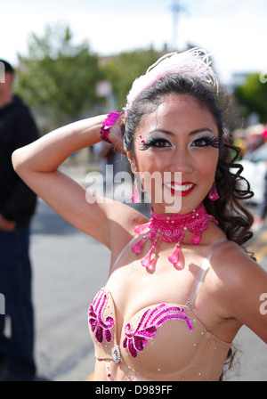 schöne Frau, die auffällig einer Pose im Karnevalstreiben im Mission District in San Francisco, Kalifornien, USA Stockfoto