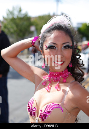 schöne Frau, die auffällig einer Pose im Karnevalstreiben im Mission District in San Francisco, Kalifornien, USA Stockfoto