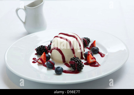 Panna Cotta mit Sommerbeeren und Himbeer-Coulis Stockfoto