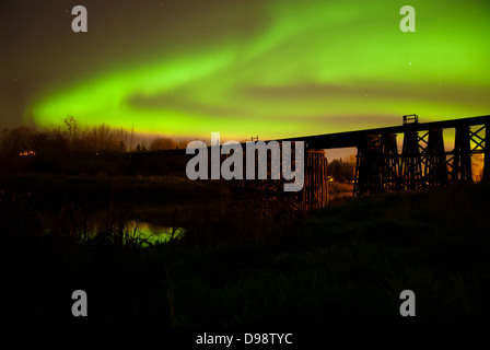 Brillanten Aurora Borealis mit in St. Albert Alberta mit einer Eisenbahnbrücke Trestle und Aurora reflektiert anzeigen Stockfoto