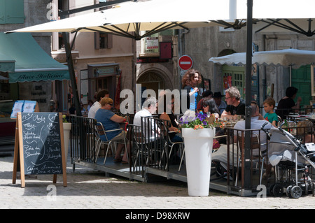 Touristen sitzen außerhalb Restaurants in Place Gambetta, Pezenas, Frankreich. Stockfoto